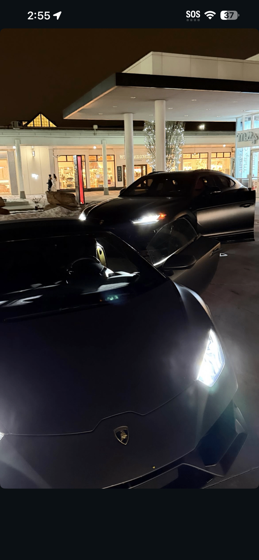 Agent next to a luxury car at sunset